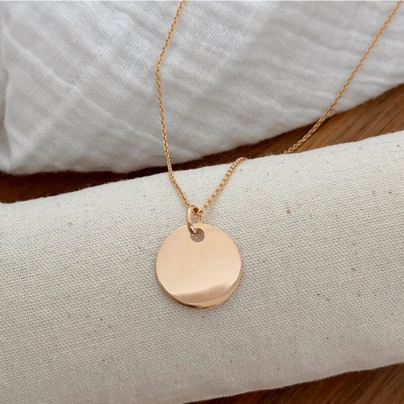 Collier pour femme en plaqué or 3 microns 18 carats personnalisable avec une gravure sur une ou deux faces. Ce collier Jolie Demoiselle est composé d'une chaîne classique en plaqué or décoré d'un joli médaillon plat, rond et lisse. Le médaillon peut être personnalisé avec un prénom, une date, quelques mots, une phrase, un symbole, le dessin de votre enfant et plus encore ! Le diamètre de la médaille est de 2 centimètres. Le collier est disponible avec plusieurs longueurs de tour de cou : 40, 45, 50, 60, 70 et 80 centimètres. Le collier est composé d'un fermoir rond sécurisé.