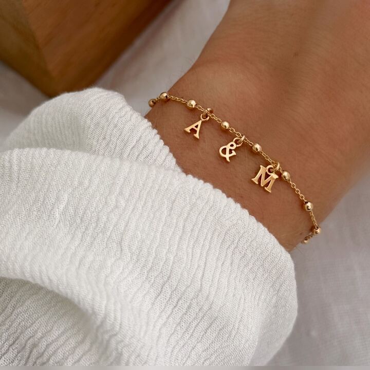 Bracelet lettre pour femme en plaqué or 3 microns 18 carats qui se compose d'une fine chaîne personnalisable avec la ou les lettres de votre choix. Vous pouvez choisir jusqu'à 6 lettres. Taille ajustable sur deux niveaux : 15 et 18 centimètres. Fermoir mousqueton rond sécurisé. C'est le cadeau parfait pour une femme.