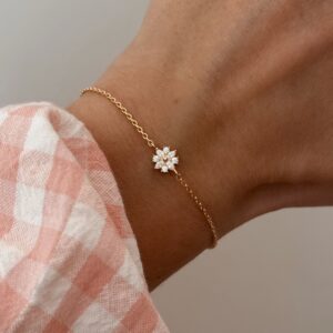 Bracelet fin pour femme en plaqué or 3 microns 18 carats monté d'un petit pendentif en forme de fleur, serti d'oxydes de zirconium. Fermoir mousqueton oval résistant et sécurisé.