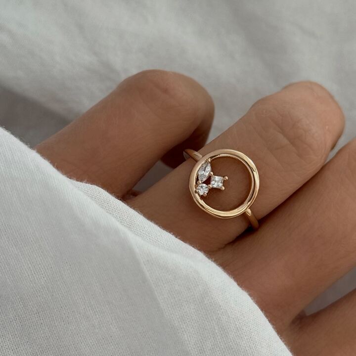 Bague cercle pour femme en plaqué or 3 microns 18 carats. Ce bijou élégant se compose d'un motif rond, ajouré au milieu, orné de 3 petits oxydes de zirconium sur le côté de la bague, à l'intérieur. Cette jolie bague est disponible de la taille 50 à 60. Si vous êtes à la recherche d'une bague de haute fantaisie, à petit prix, élégante et de qualité, cette bague est faite pour vous !