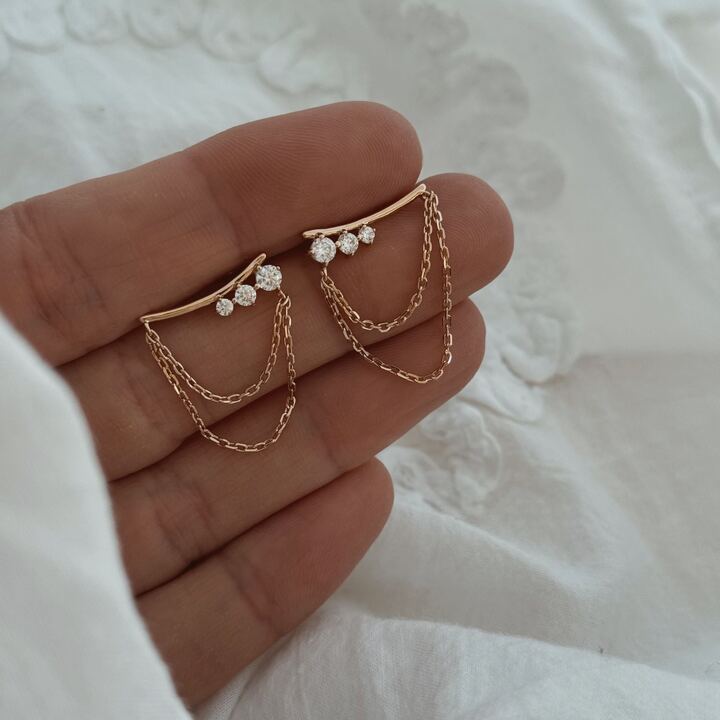 Boucles d'oreilles montantes pour femme en plaqué or 3 microns 18 carats Le bijou se compose d'une tige montante ornée d'oxydes de zirconium et de deux petites chaînette Longueur : 1.7 cm Longueur totale : 2.3 cm La tige vient se plaquer derrière le lobe Par mesure d’hygiène, les boucles d’oreilles ne sont ni reprises, ni échangées