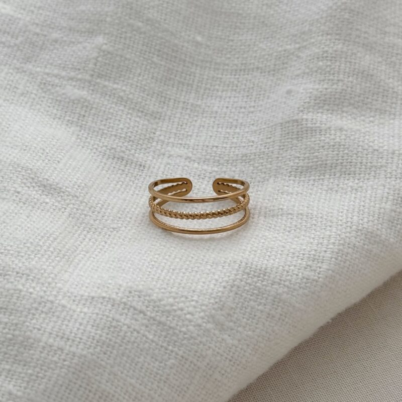 Bague large en acier inoxydable doré Le bijou se compose de 3 anneaux : deux au motif lisse et un torsadé au centre Largeur : 0.7 cm Taille légèrement ajustable du 54 à 56