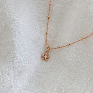 Collier pour femme en plaqué or 3 microns 18 carats qui se compose d'une fine chaîne décorée de petites billes et d'un pendentif floral discret et élégant. Le pendentif en forme de fleur se compose de 5 petites pétales rondes, au centre de la fleur est serti un oxyde de zirconium. Le collier est disponible dans différentes tailles : 38, 40, 45 ou encore 50 cm. Le bijou dispose d'un fermoir mousqueton rond, très facile à ouvrir et à fermer.