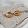 Boucles d'oreilles pour femme en acier inoxydable doré très légères à porter. Le bijou se compose de deux empiècement ovales bombés de tailles différentes, posé l'un sur l'autre. La boucle mesure 2 cm de longueur. Le derrière de chaque pièce est creux. Fermoir papillon sécurisé.