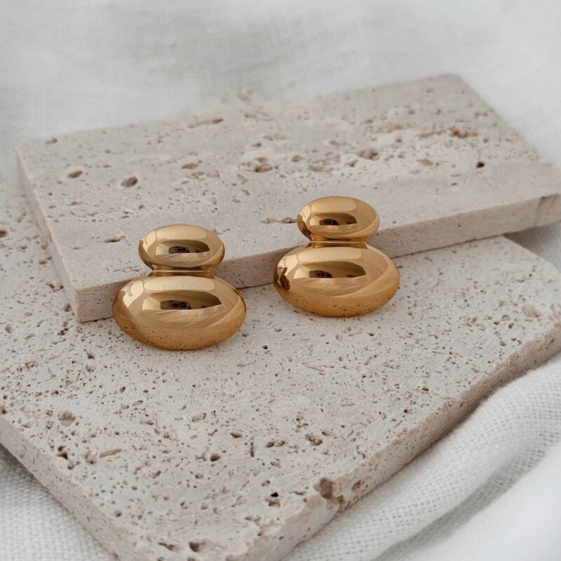 Boucles d'oreilles pour femme en acier inoxydable doré très légères à porter. Le bijou se compose de deux empiècement ovales bombés de tailles différentes, posé l'un sur l'autre. La boucle mesure 2 cm de longueur. Le derrière de chaque pièce est creux. Fermoir papillon sécurisé.