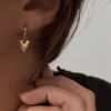 Petites boucles d'oreilles type créoles en acier inoxydable doré décoré d'un petit coeur. Dimensions de la créoles 1,1 x 1,1 centimètre de diamètre.