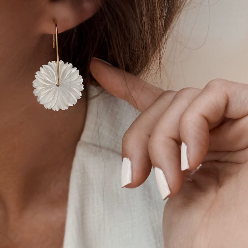 Boucles d'oreilles pour femme pendantes en acier inoxydable doré, décorées d'une grosse fleur en nacre blanche. Longueur de la boucle d'oreille : 4,2 centimètres.