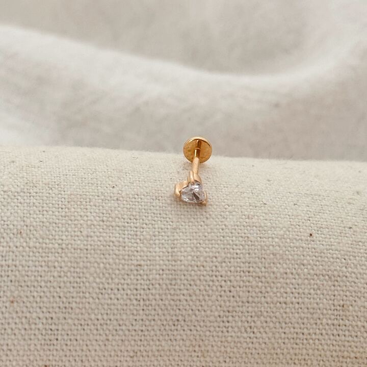 Piercing en plaqué or 3 Microns 18 carats monté d'un oxyde de zirconium en forme de coeur. La barre labret est en titane et permet d'être retiré plus facilement qu'un fermoir à visser.