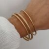 Bracelets style joncs en acier inoxydable doré Chacun des bracelets est décoré d'un motif différent Lot de trois pièces Largeur : 7 cm Taille non ajustable  Garantie sans nickel, sans cadmium, sans sel de plomb Les bracelets Hélia résistent à l’eau et ne noircissent pas