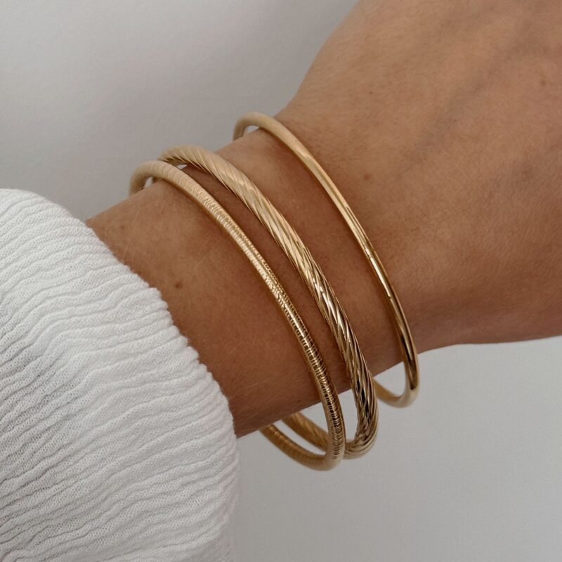 Bracelets style joncs en acier inoxydable doré Chacun des bracelets est décoré d'un motif différent Lot de trois pièces Largeur : 7 cm Taille non ajustable  Garantie sans nickel, sans cadmium, sans sel de plomb Les bracelets Hélia résistent à l’eau et ne noircissent pas