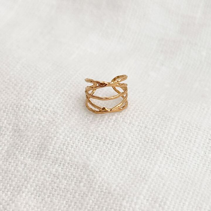 Bague d'oreille ajustable également appelée ear cuff, au design multi-rang ajouré, en acier inoxydable doré. Ce bijou s'adapte à toutes les morphologies d'oreille.