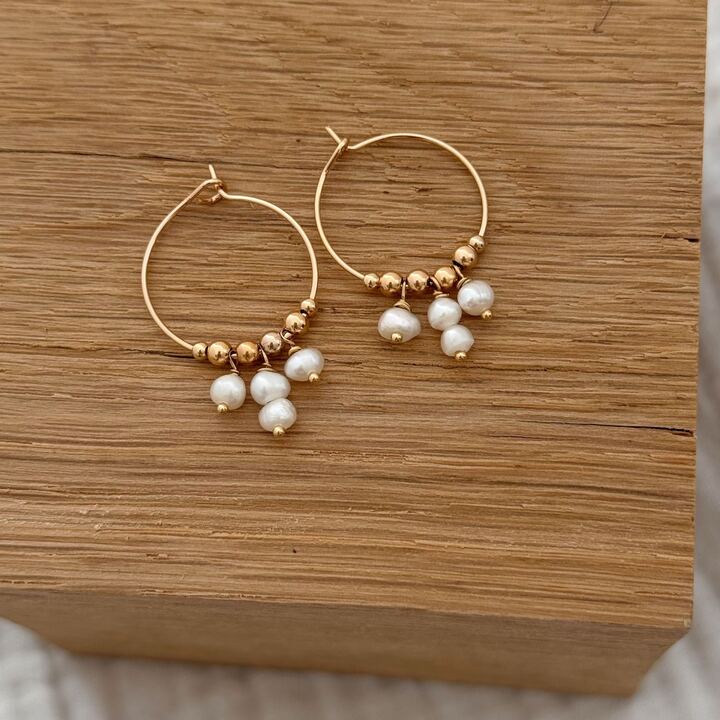 Boucles d'oreilles pour femme style créoles pendantes décorée de petites billes dorée et de perles d'eau douce blanches. La longueur d'une boucle est de 3 cm. Elles sont très légères à porter. La paire de boucles d'oreilles a été entièrement réalisée à la main depuis notre atelier situé en normandie.