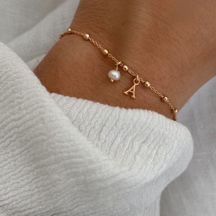 Bracelet pour femme en plaqué or 3 microns 18 carats, personnalisable avec la lettre de votre choix. La lettre est entièrement lisse. Elle mesure 0,7 cm. La chaîne est composée de petites billes sur tout le pourtour du bracelet.