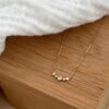 Collier plaqué or 3 microns 18 carats pour femme composé d'une chaîne classique et d'une barrette courbée et sertie de petits oxydes de zirconium.