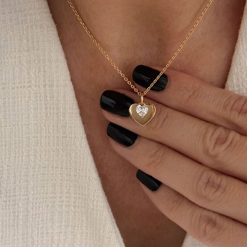 Collier pour femme en plaqué or 3 microns 18 carats qui se compose d'une chaîne classique et d'un pendentif type médaille, en forme de coeur, surmonté d'un second petit coeur en oxyde de zirconium. C'est le cadeau parfait à offrir à une femme. Fermoir mousqueton rond. Différentes tailles de tour de cou sont disponibles : 40, 45 et 50 centimètres.