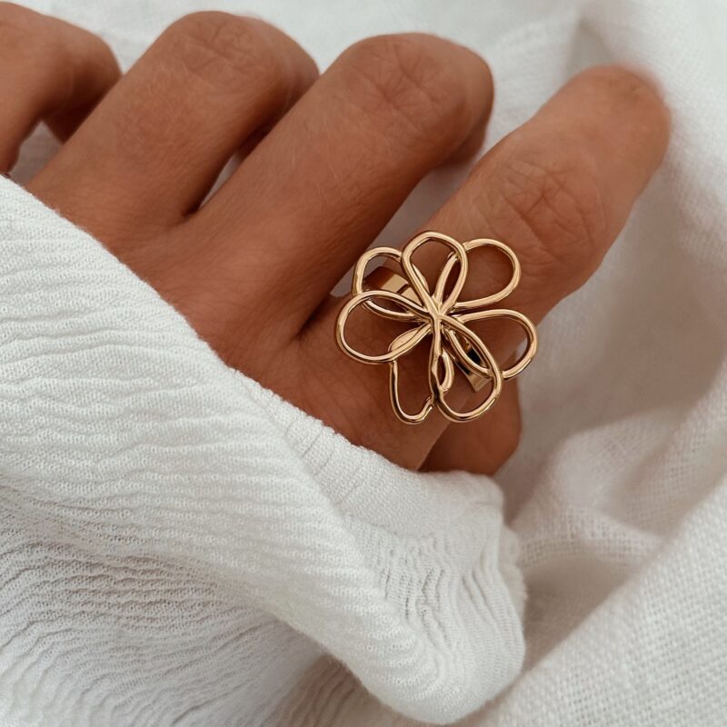 Bague large en acier inoxydable doré  Design : Bijou décoré d'une fleur à la forme irrégulière au fini lisse Taille ajustable de 54 à 58 Diamètre de la fleur : 2.3 cm