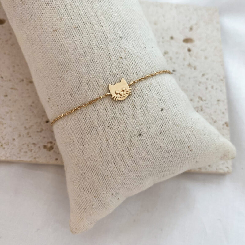 Bracelet en plaqué or 3 microns 18 carats Le bijou est décoré d'une fine chaîne et d'un motif tête de chat Ajustable sur deux niveaux : 13 cm et 15 cm Fermoir mousqueton