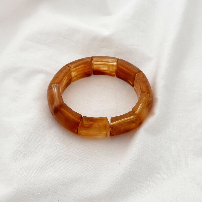 Bracelet élastique style jonc très tendance ! Le bijou se compose de tubes en résine Coloris marron Dimensions : La largeur du bracelet est de 2 cm et le diamètre intérieur est de 6 x 6 cm Nos conseils : Afin d'éviter que l'élastique ne se détende prématurément, nous vous conseillons d'enfiler le bracelet délicatement en le faisant glisser le long de votre main sans trop tirer sur l'élastique Étant de l'acétate, leurs couleurs peuvent varier d'un modèle à l'autre
