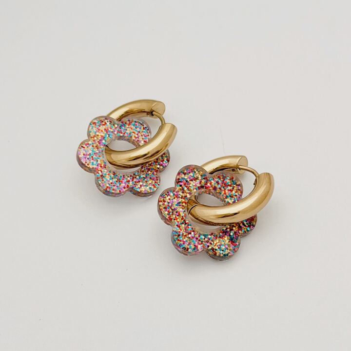 Boucles d'oreilles créoles larges en acier inoxydable doré lisse, décorées d'une fleur à paillettes multicolore en acétate.