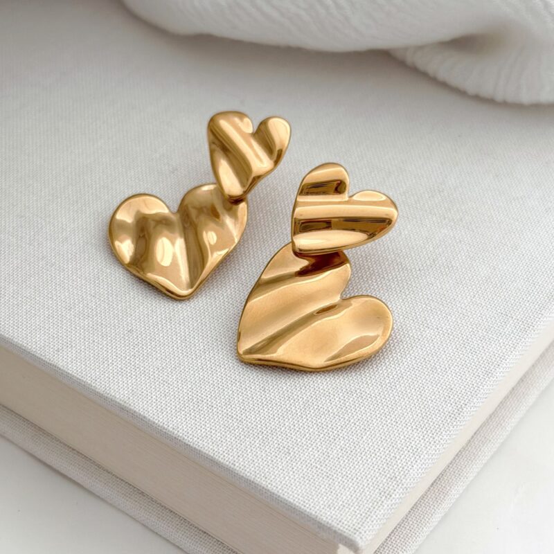 Boucles d'oreilles pendantes en acier inoxydable doré Le bijou se compose de deux empiècements en forme de cœur martelé Longueur : 3,5 cm Fermoir papillon + poussoir en silicone Par mesure d’hygiène, les boucles d’oreilles ne sont ni reprises, ni échangées Cette paire est garantie sans nickel, sans cadmium, sans sel de plomb Elle résiste à l’eau et ne noircit pas.