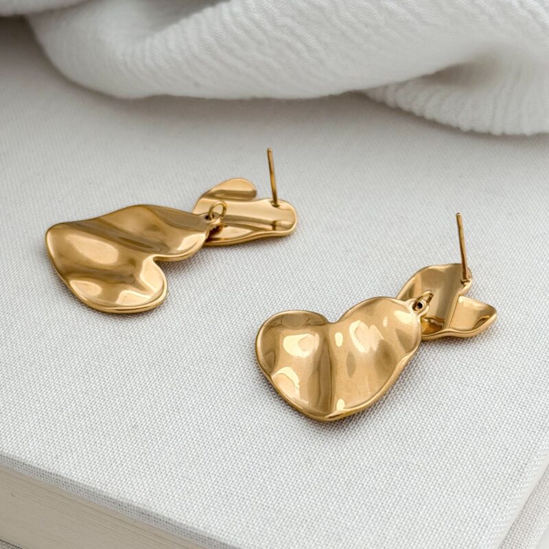 Boucles d'oreilles pendantes en acier inoxydable doré Le bijou se compose de deux empiècements en forme de cœur martelé Longueur : 3,5 cm Fermoir papillon + poussoir en silicone Par mesure d’hygiène, les boucles d’oreilles ne sont ni reprises, ni échangées Cette paire est garantie sans nickel, sans cadmium, sans sel de plomb Elle résiste à l’eau et ne noircit pas.