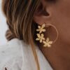 Boucles d'oreilles grand format en acier inoxydable en forme de cercle décoré de fleur sur la moitié.
