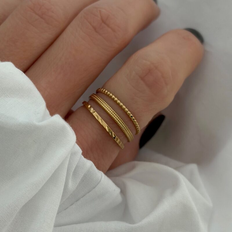 Bague large réglable en acier inoxydable doré Le bijou se compose de 3 anneaux de différents styles Largeur : 0.9 cm Taille légèrement ajustable du 54 à 56 Cette bague est garantie sans nickel, sans cadmium, sans sel de plomb Elle résiste à l’eau et ne noircit pas