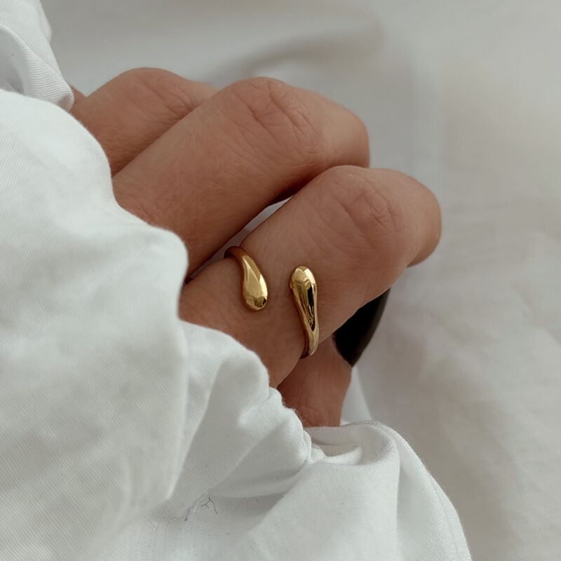 Bague pour femme tendance, ouverte sur le dessus, qui se compose d'un motif ) la ligne légèrement courbée et bombée, entrelacée. Cette bague est réglable et facile à porter au quotidien.