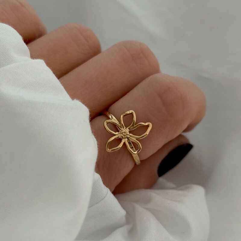 Bague en acier inoxydable doré Design : Bijou décoré d'une fleur ajourée à la forme irrégulière au fini martelé Taille ajustable de 54 à 58 Diamètre de la fleur : 1.1 x 0.9 cm