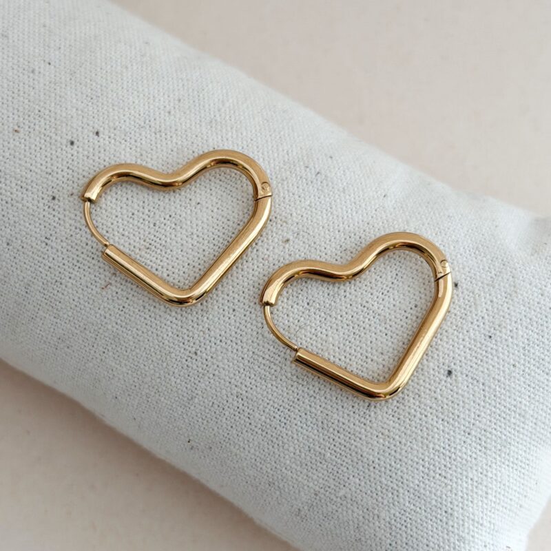 Boucles d'oreilles style créoles large tendance en acier inoxydable doré Design : Bijou motif cœur XXL au fini lisse Fermoir à clip Largeur : 2 cm Longueur totale : 2.5 cm Par mesure d’hygiène, les boucles d’oreilles ne sont ni reprises, ni échangées Cette paire est garantie sans nickel, sans cadmium, sans sel de plomb Elle résiste à l’eau et ne noircit pas.