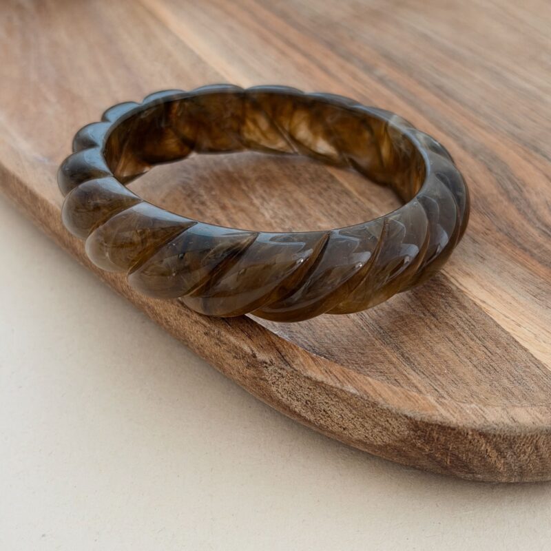 Bracelet type jonc très tendance ! Design : Le bijou est en résine avec un effet torsadé coloris marron foncé légèrement nuancé Dimensions : La largeur du bracelet est de 1.7 cm et le diamètre intérieur est de 6.6 cm Non ajustable Étant de l'acétate, leurs couleurs peuvent varier d'une pièce à l'autre Disponible en écru