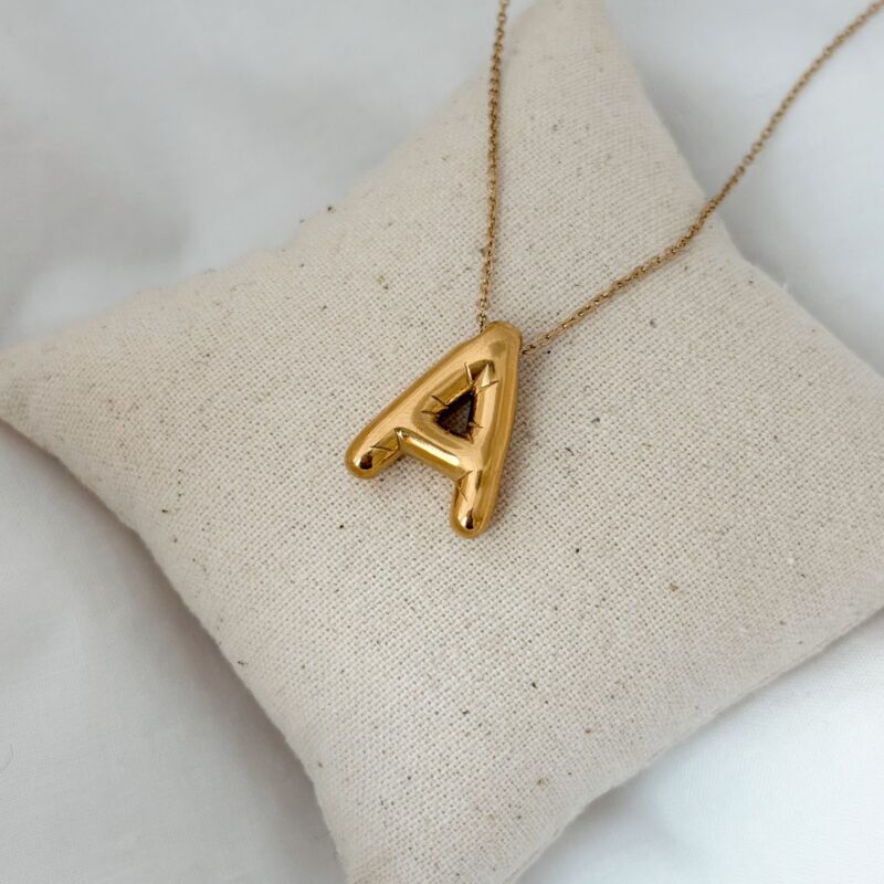 Collier personnalisé en acier inoxydable doré  Design : Le bijou se compose d'une chaîne classique décorée d'un pendentif lettre au format XXL bombé Dimensions de la lettre : 1.5 x 2 cm Choisissez l'initiale de votre choix Fermoir mousqueton rond