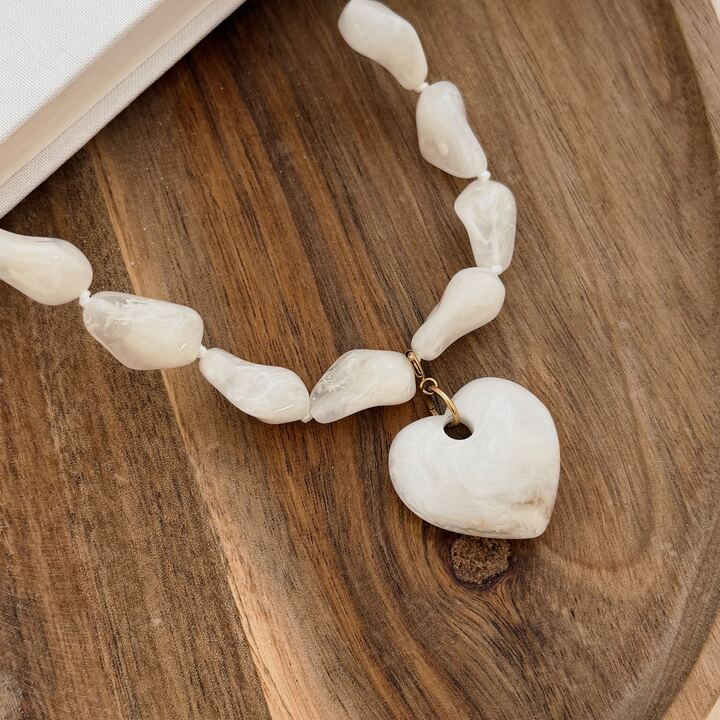 Collier pour femme imposant avec ses grosses perles en résine beiges à la forme irrégulière et son grand pendentif en forme de coeur. C'est la tendance du moment ! Ce collier apporte une touche d'originalité à une tenue. Il est réglable sur 7 centimètres de 40 à 47 centimètres.