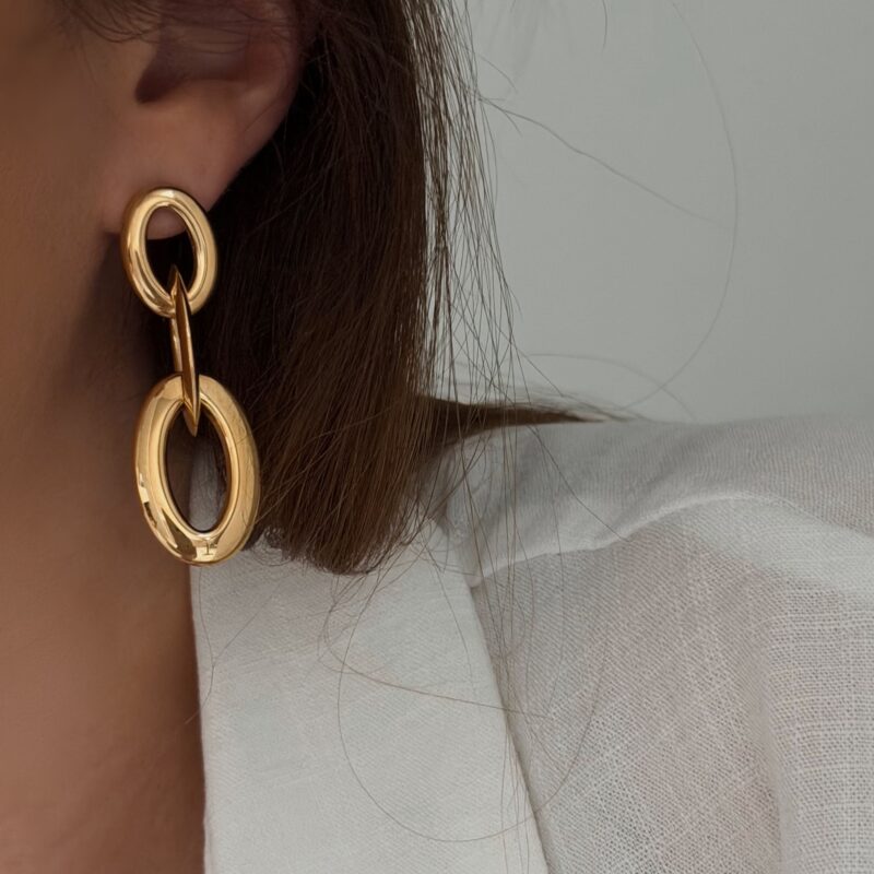 Boucles d'oreilles au format XXL pendantes en acier inoxydable doré Bijou au fini lisse, représentant trois anneaux ovales entrelacés Longueur d'une boucle : 5 cm Fermoir papillon + poussoir en silicone Poids d'une boucle : 10g Par mesure d’hygiène, les boucles d’oreilles ne sont ni reprises, ni échangées La paire de boucles d'oreilles est très légères ! Cette paire est garantie sans nickel, sans cadmium, sans sel de plomb. Elle résiste à l’eau et ne noircit pas.