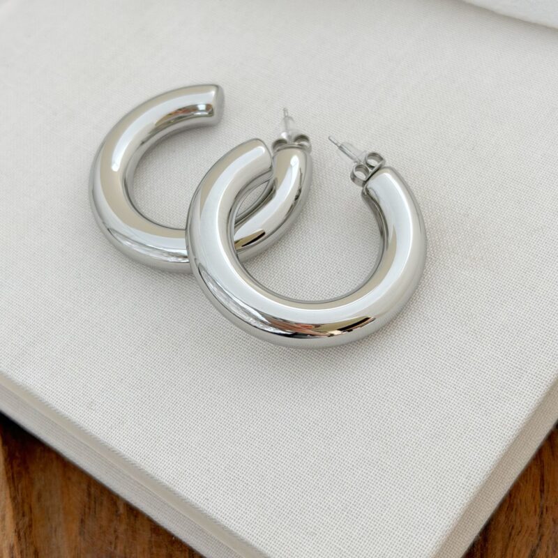 Boucles d'oreilles tendances grandes créoles en acier inoxydable argenté. Ces créoles pour femme sont très légères à porter au quotidien. Elles possèdent un fini lisse et brillant afin d'illuminer votre visage. Elles ont un diamètre de 4 centimètres.
