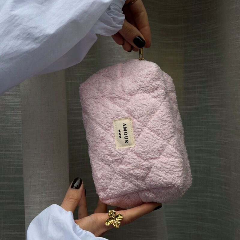 Trousse de toilette pour femme mot amour coloris rose poudré. La trousse possède un grand format, idéal pour transporter tout type d'affaire que ce soit du maquillage, des accessoires ou autre. Elle est décoré d'un effet matelassé.