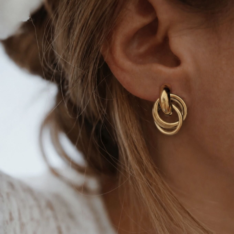 Boucles d'oreilles pour femme en acier inoxydable doré. Ce bijou au style vintage ce compose d'un design avec des empiècements entrelacés.