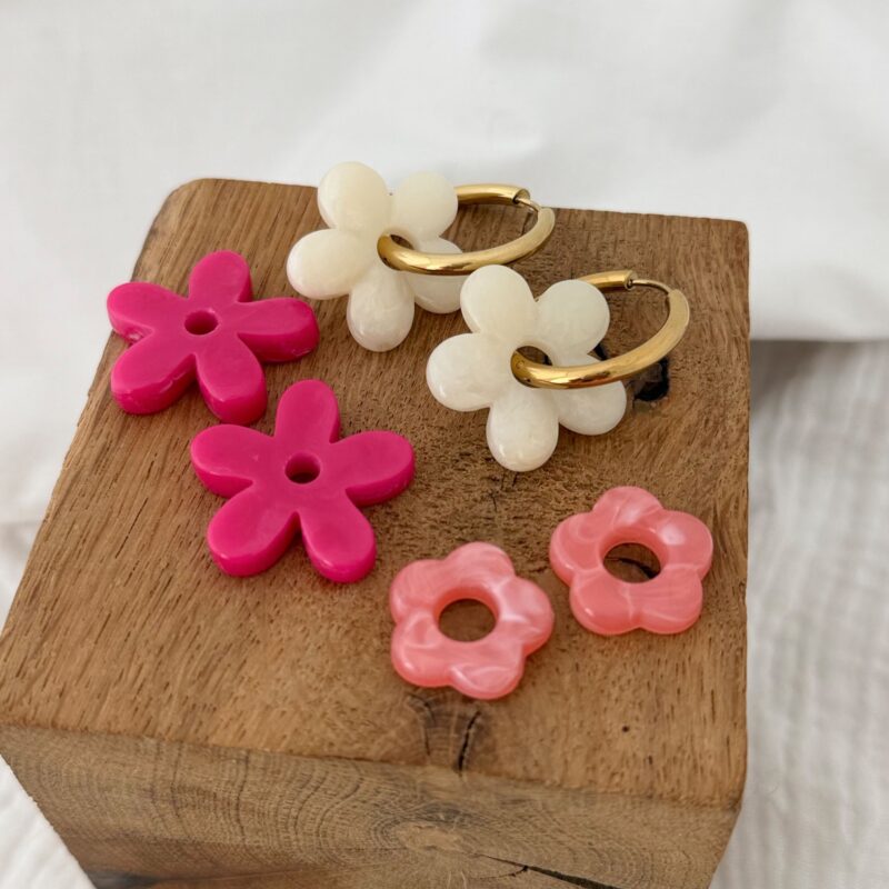 Trio de boucles d'oreilles interchangeables pour femme qui se compose d'une grande créole en acier inoxydable doré et de 3 paires de fleurs en acétate.