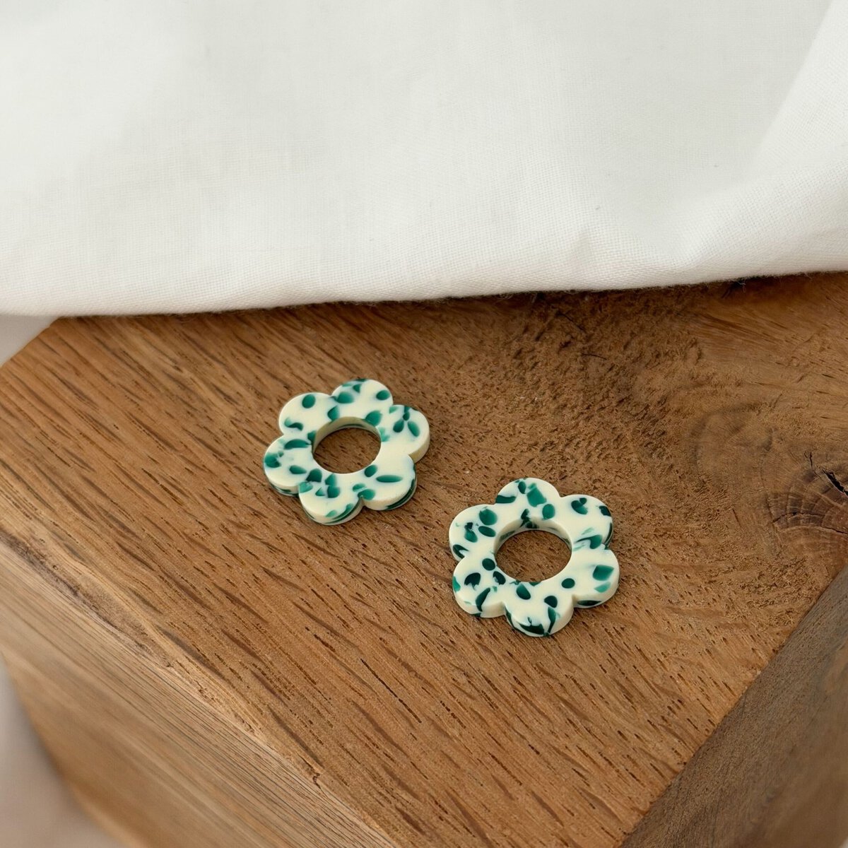 Boucles d'oreilles interchangeables pour femme, le must-have bijoux du moment ! Découvrez notre paire de fleurs en acétate, coloris blanc et vert motif Terrazzo. Ce bijou sera à glisser sur votre paire de boucles d'oreilles type créoles favorite ! Diamètre de la fleur : 0,8 centimètres.