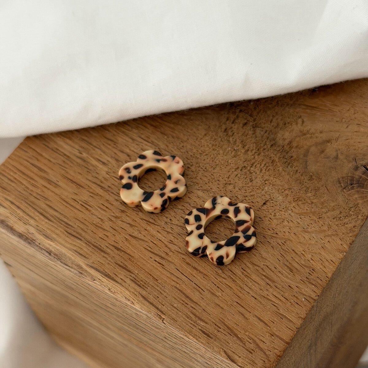 Boucles d'oreilles interchangeables pour femme, le must-have bijoux du moment ! Découvrez notre paire de fleurs en acétate, coloris beige et marron, motif léopard. Ce bijou sera à glisser sur votre paire de boucles d'oreilles type créoles favorite ! Diamètre de la fleur : 0,8 centimètres.