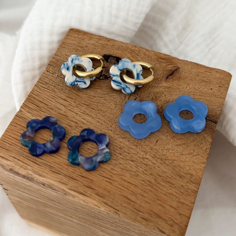 Trio de boucles d'oreilles tendances composé d'une paire de créoles dorées et de trois paires fleurs bleues.