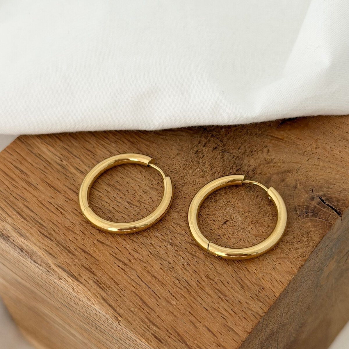 Boucles d'oreilles type grandes créoles en acier inoxydable doré au fini lisse. Cette paire de créoles est parfaite si vous souhaitez y faire glisser un pendant comme nos fleurs Flory en acétate ou encore nos pendentifs Candice.