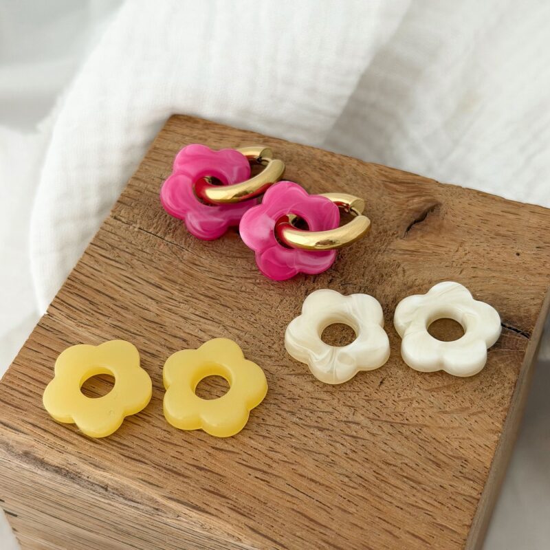Coffret boucles d'oreilles interchangeables avec fleurs en acétate, couleurs rose, jaune et beige.