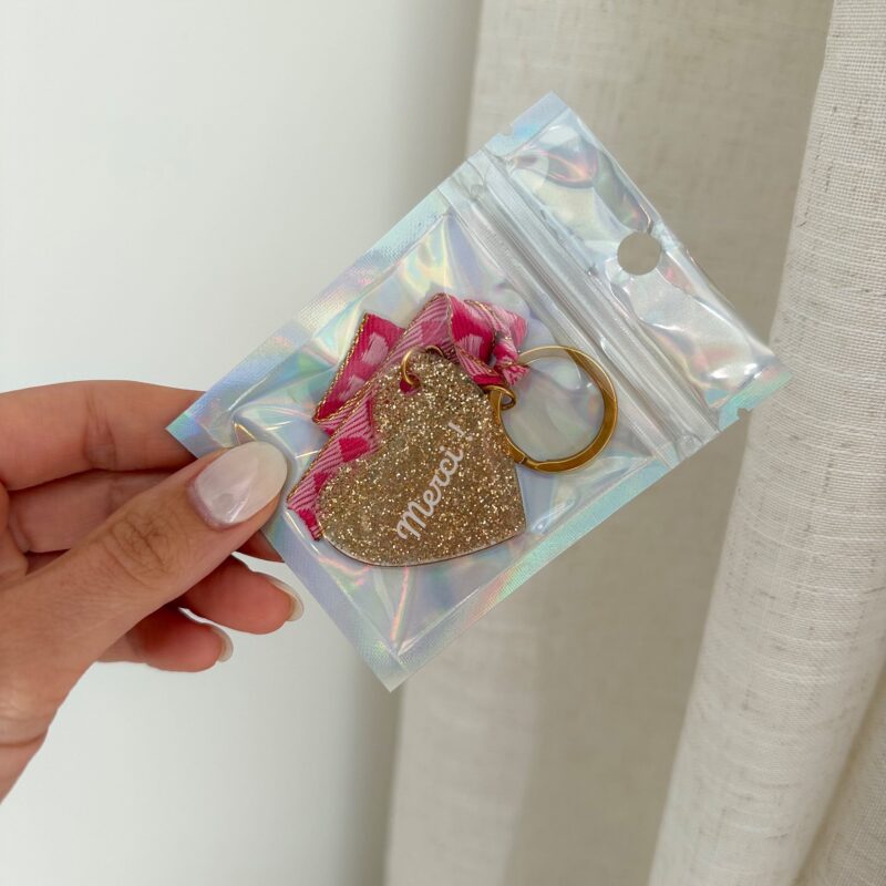 Emballage Porte clé grigri Pia en acier inoxydable doré et ruban brodé coloris rose coeur pailleté avec inscrit merci ! collection jolie demoiselle